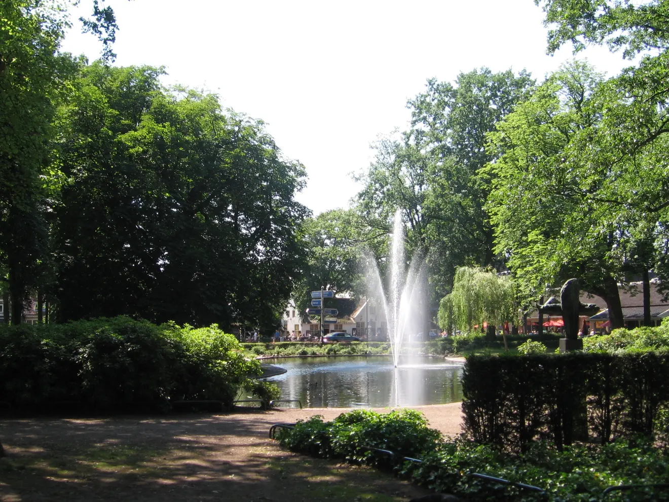 Vijver met fontein tussen de bomen op de Brink in Laren
